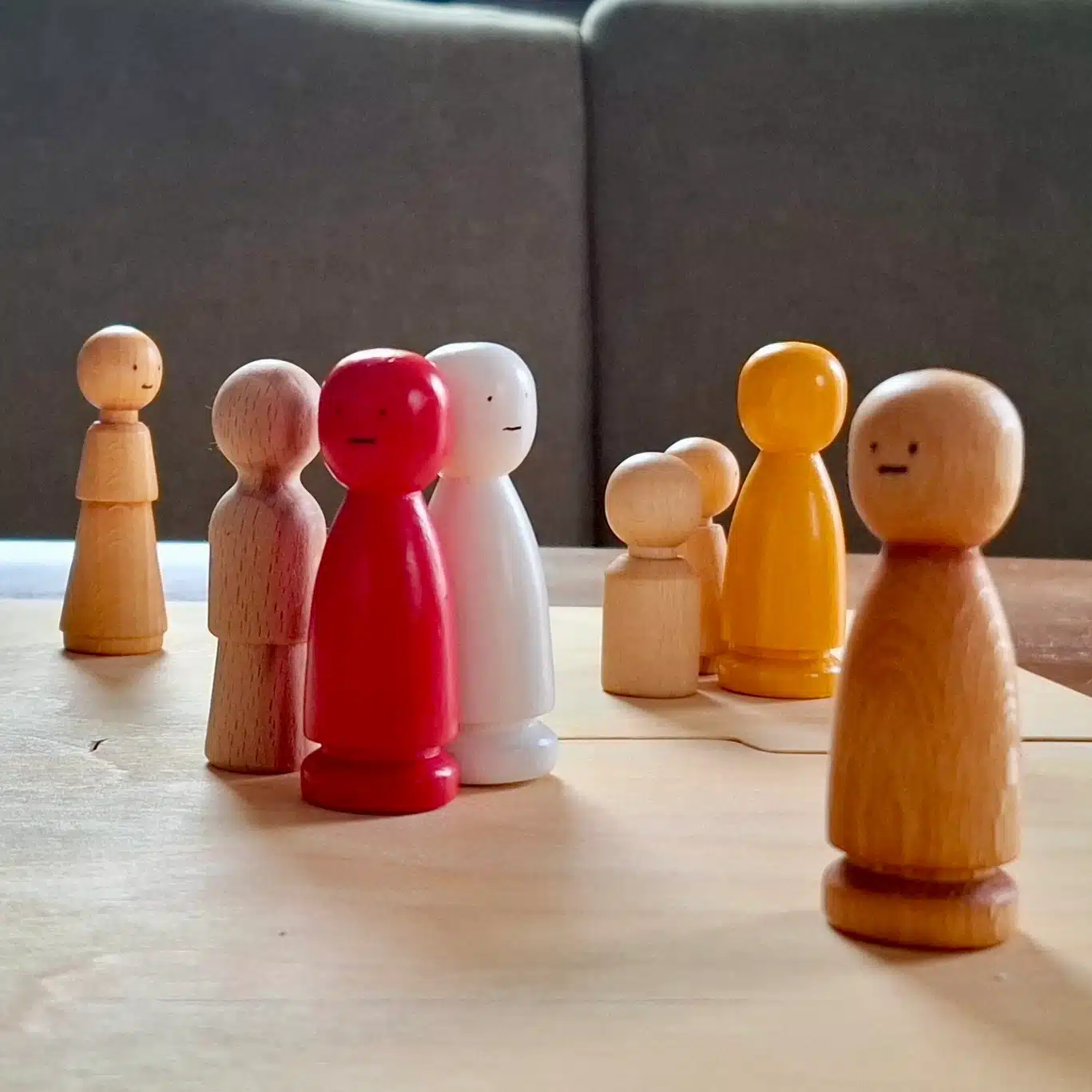 bunte Figuren stehen auf Systembrett, Methode in systemischer Beratung