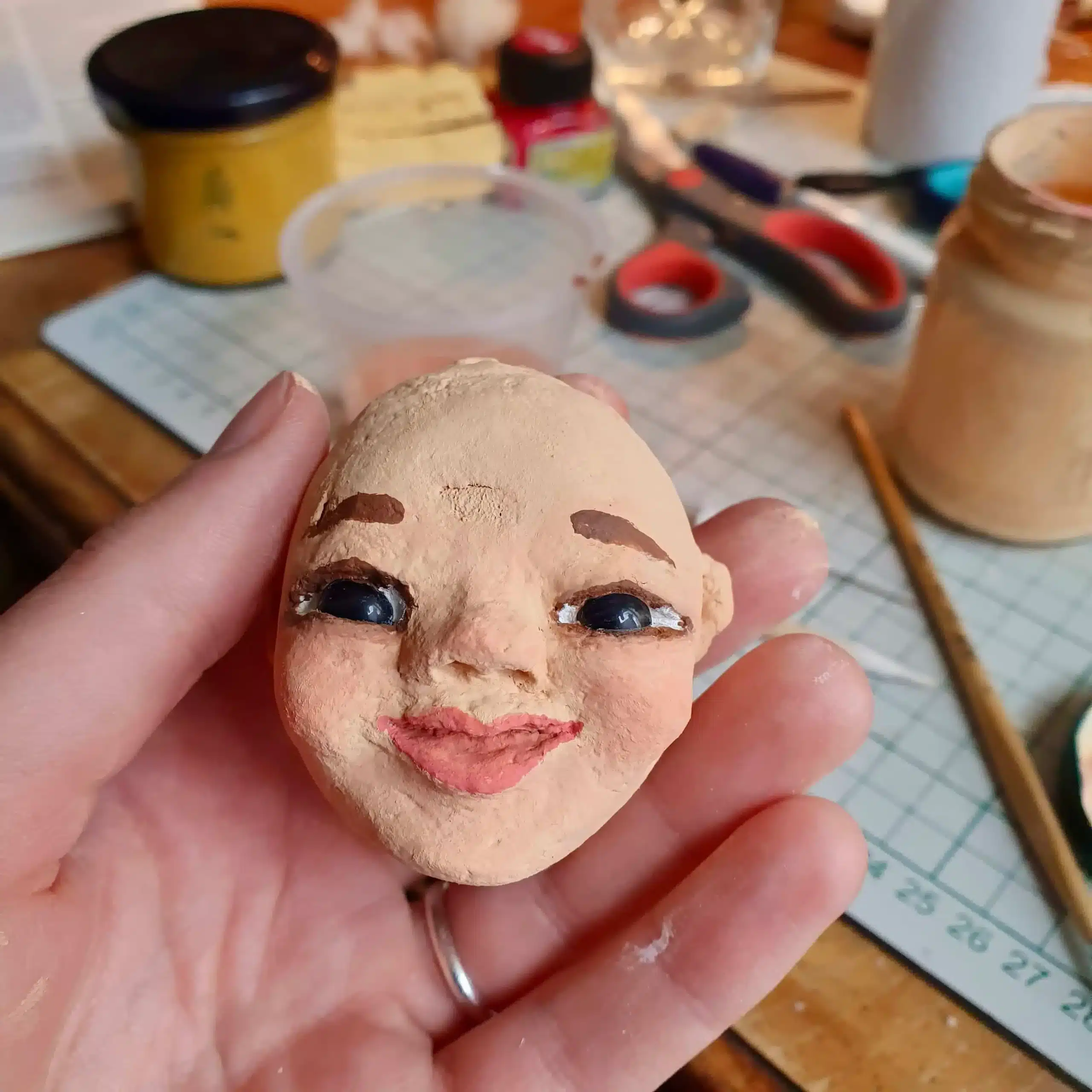 Puppenkopf in Hand wird bemalt in Figurenspieltherapie