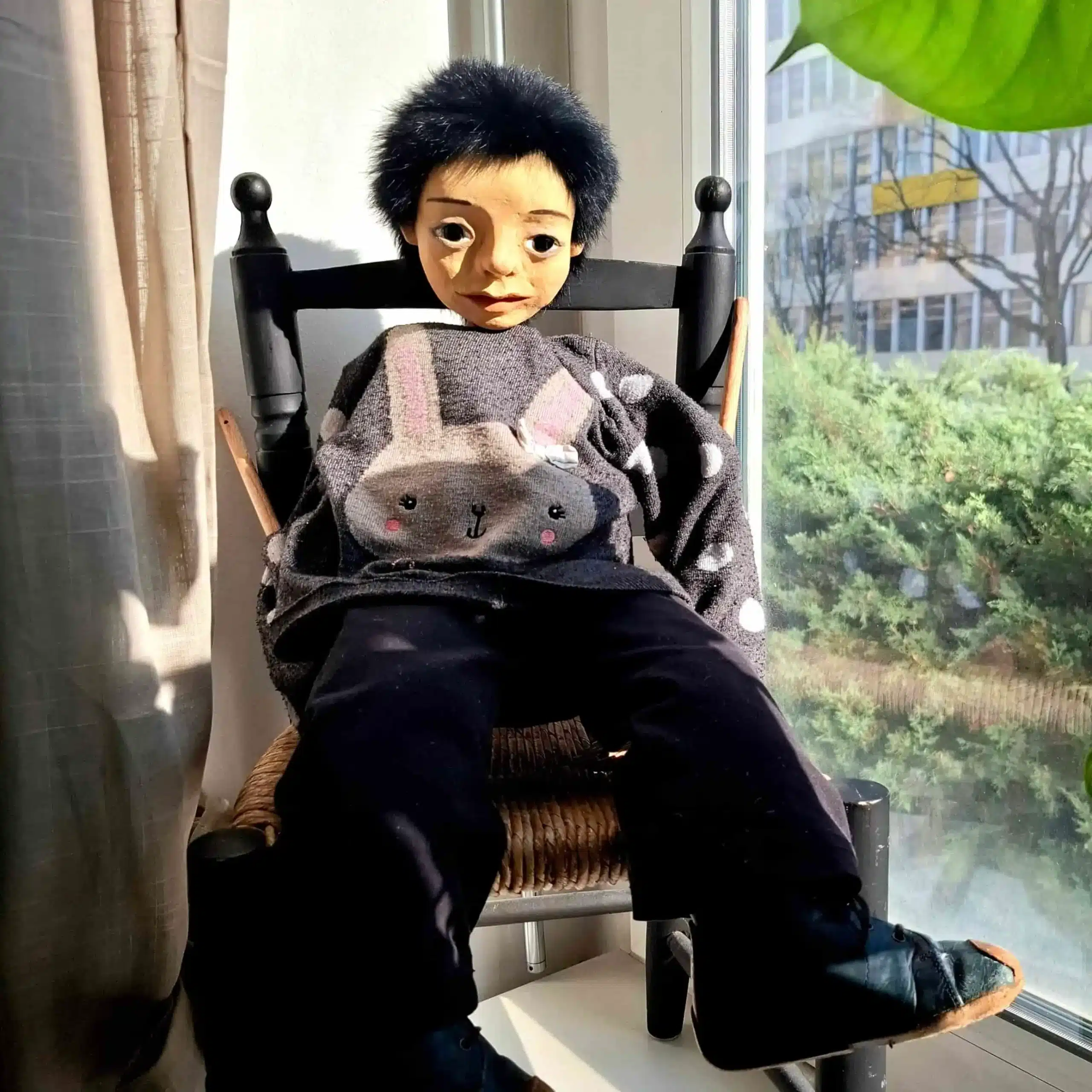 Grosse Puppe Sitzt am Fenster